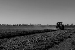 Aratura di un campo e raffinamento con un trattore, immagine in bianco e nero